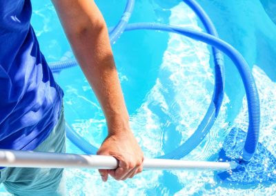 swimming pool cleaning. a man is cleaning the pool. service care
